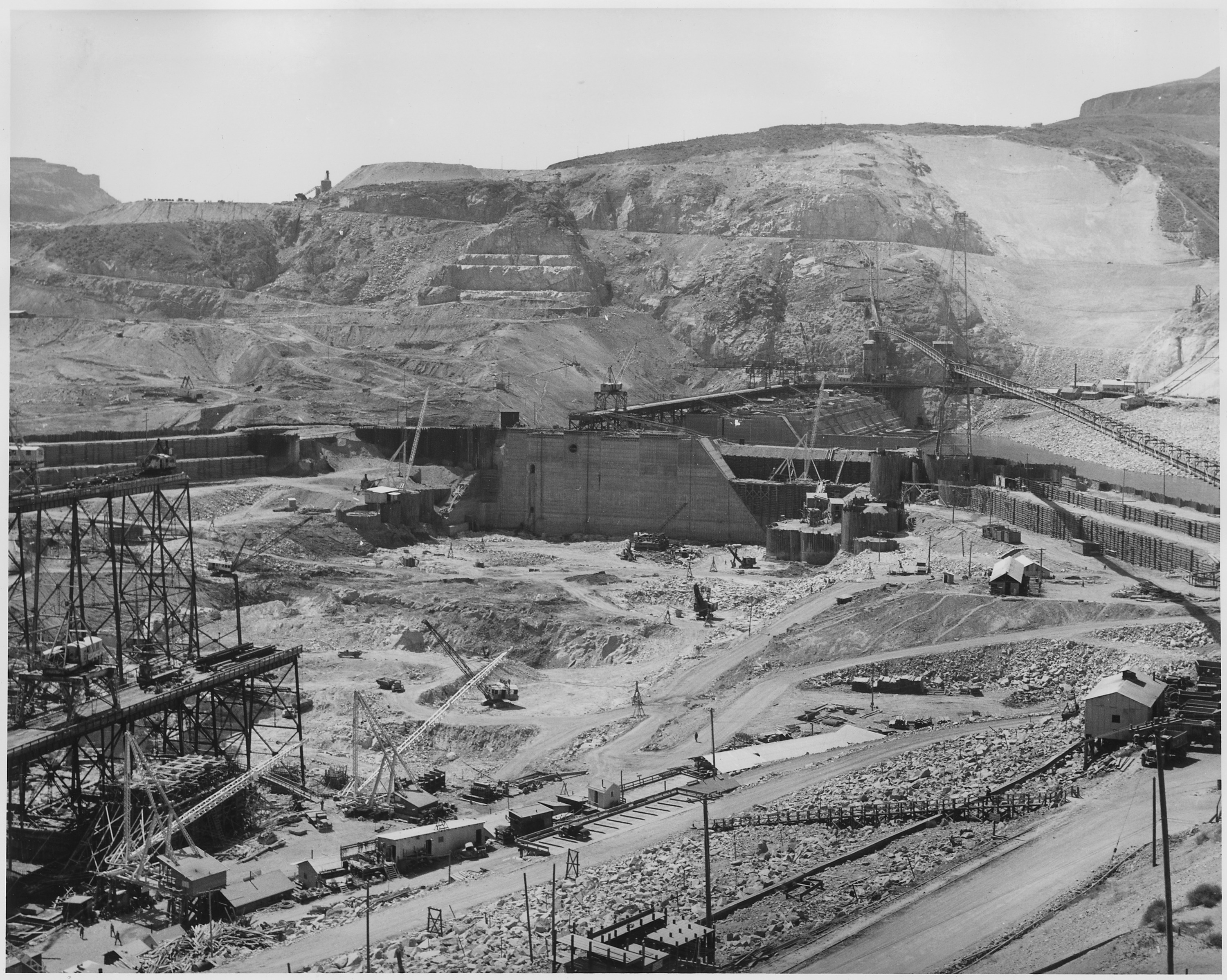 Historyczne zdjęcie wielkiego placu budowy zapory Grand Coulee — jednej z największych publicznych inwestycji energetycznych USA.
