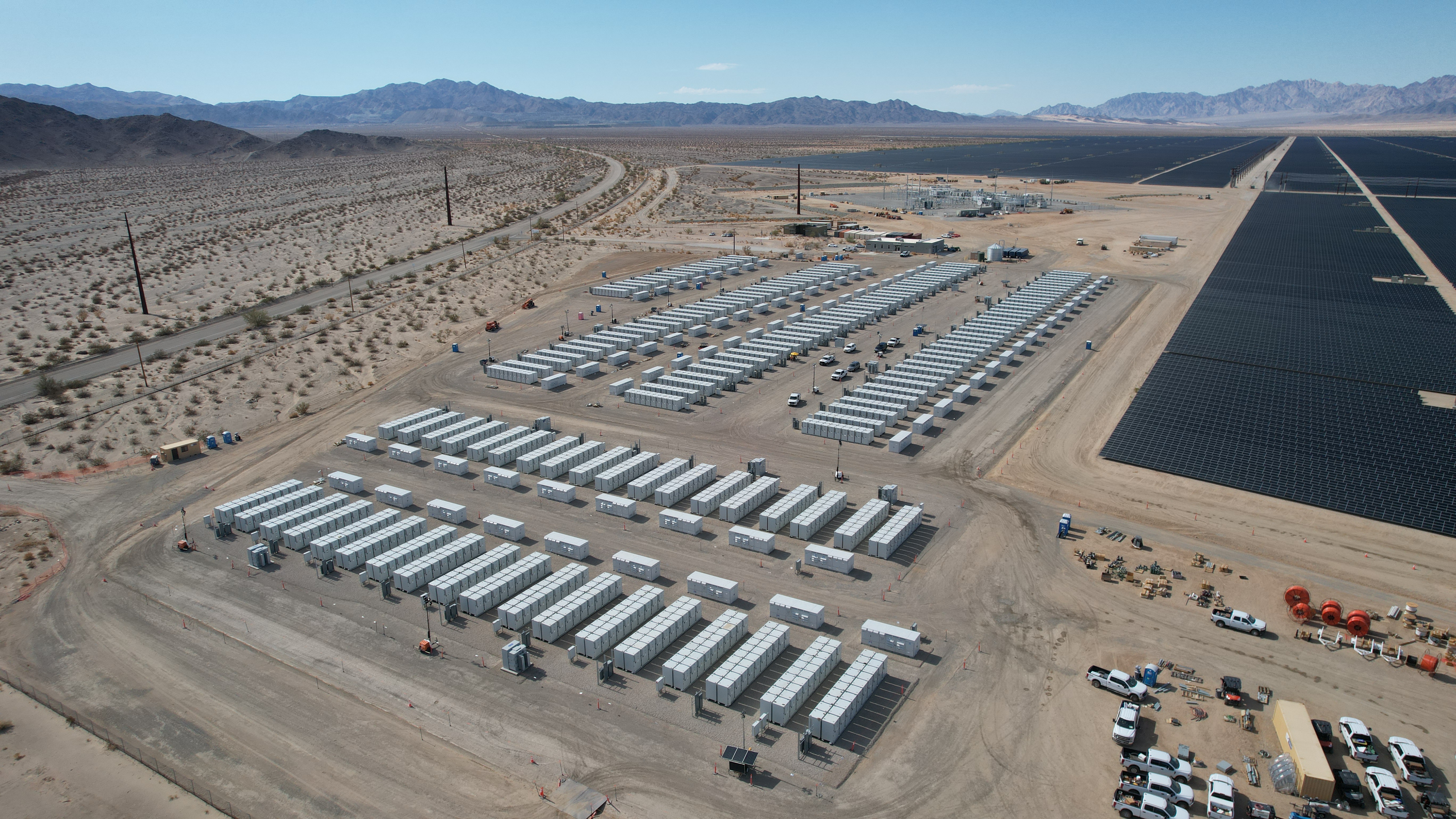 Rzędy kontenerowych bateryjnych magazynów energii przy farmie fotowoltaicznej Desert Sunlight, widok z lotu ptaka.